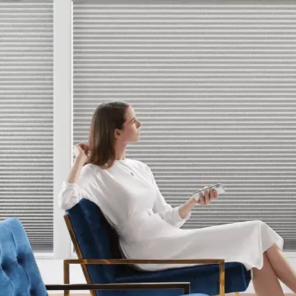 Woman seated beside cellular shades